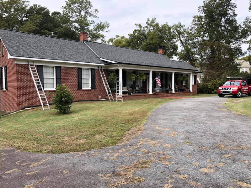 Professional Gutter Cleaning truck and crew at a ranch-style Atlanta home