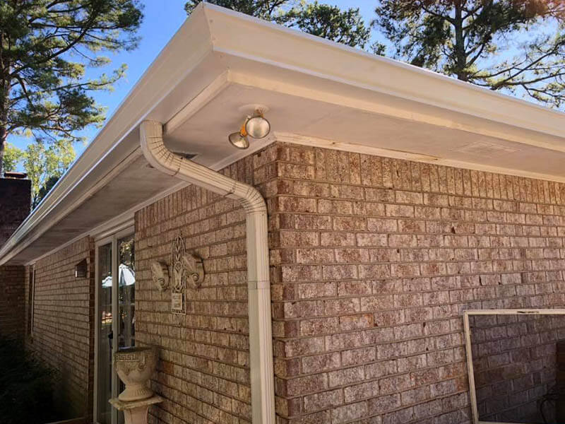 Close-up of clean downspout and gutter in warm sunlight, showing craftsmanship detail